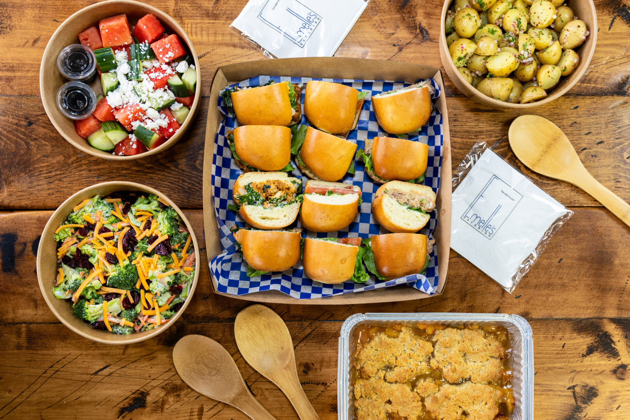 family picnic with six sandwiches, three salads, and ginger peach cobbler