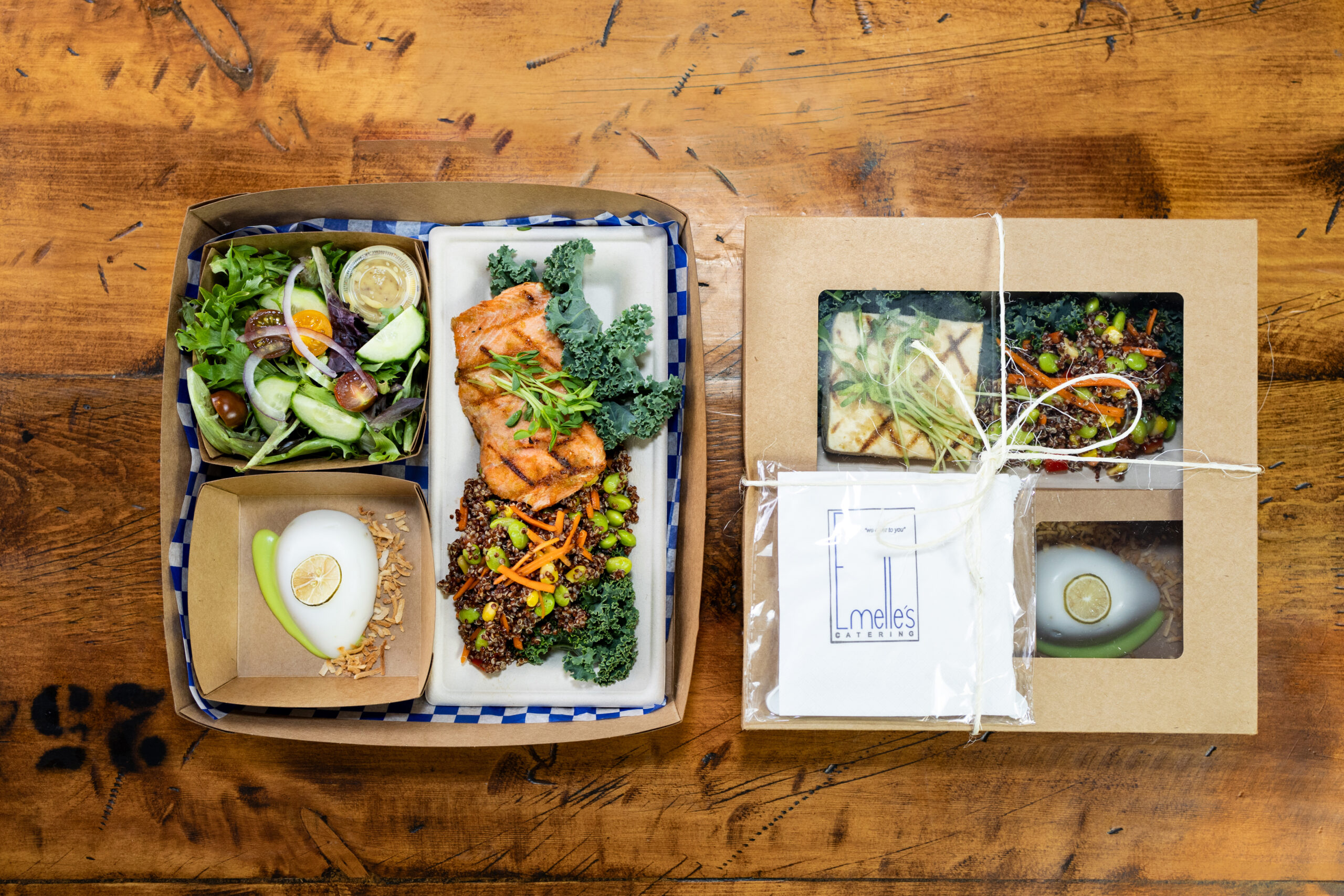 two picnic boxes, one with salmon, salad and a panna cotta, the other with tofu. salad, and a panna cotta