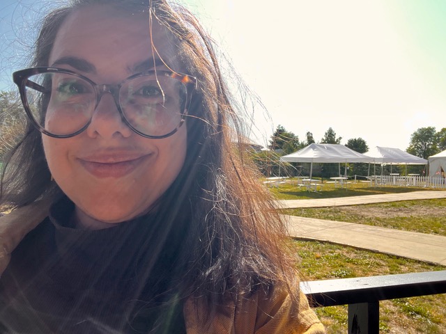 A selfie of Mishelle Cuttler in the sunshine, with the Marquee tent behind her.