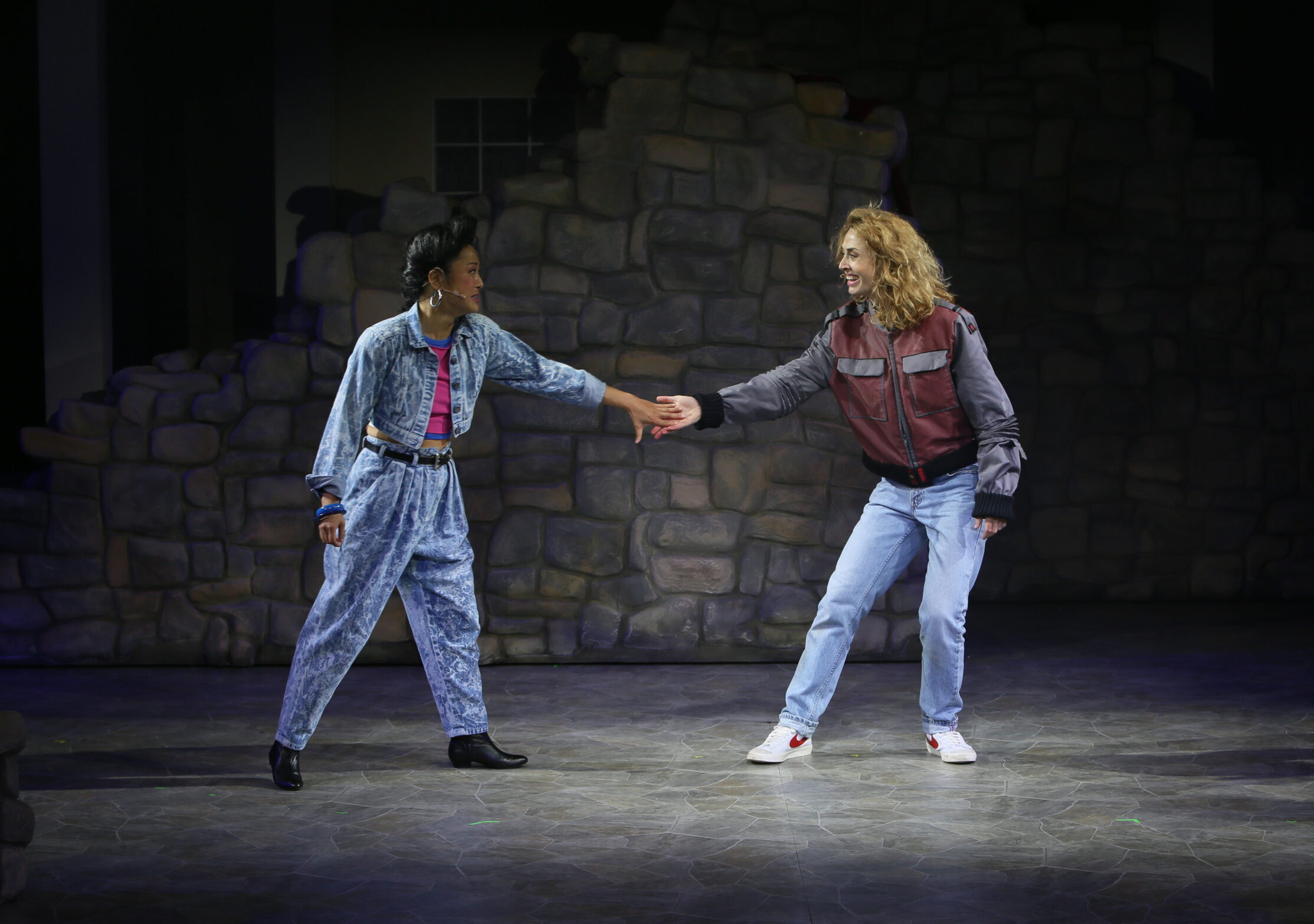 Silvia and Julia look to each other with hands outstretched.