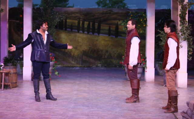 Don John, Don Pedro, and Claudio stand on the stage