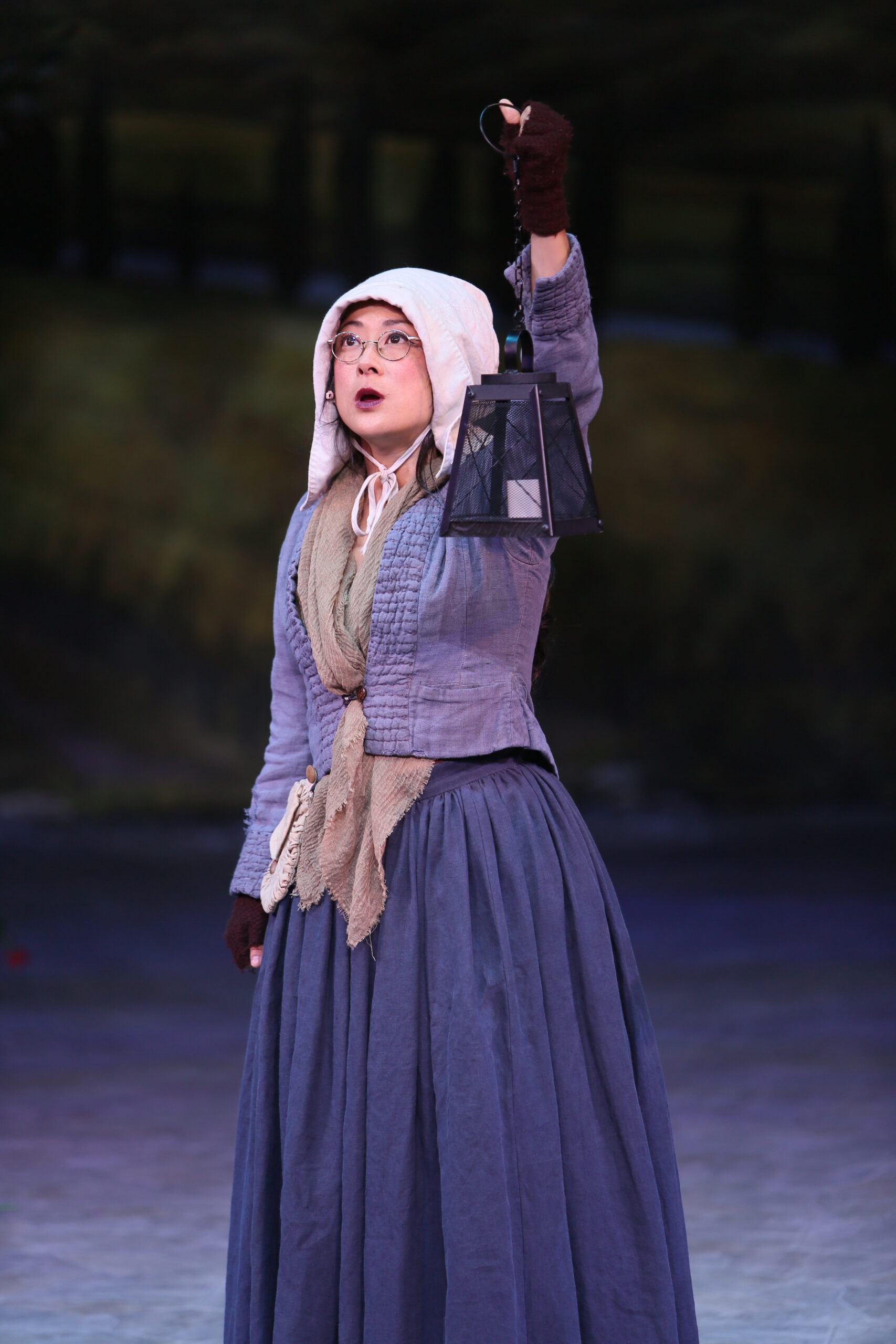 Seacole stands with her arm raised and her lantern in hand