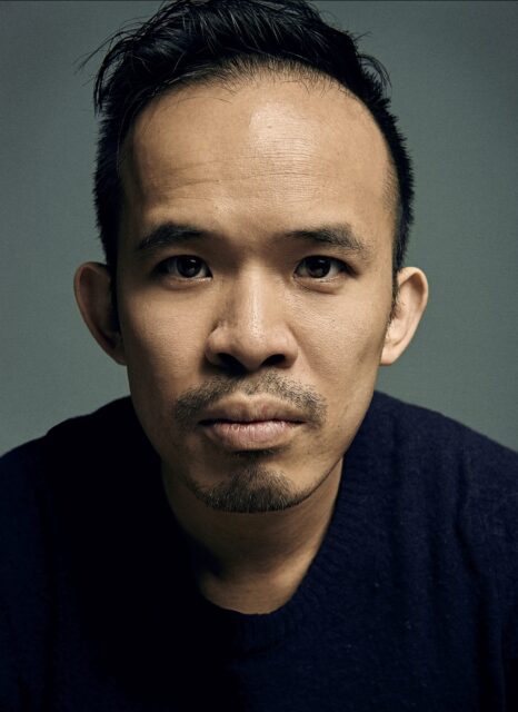 A headshot of Christopher Lam wearing a dark blue crewneck sweater.